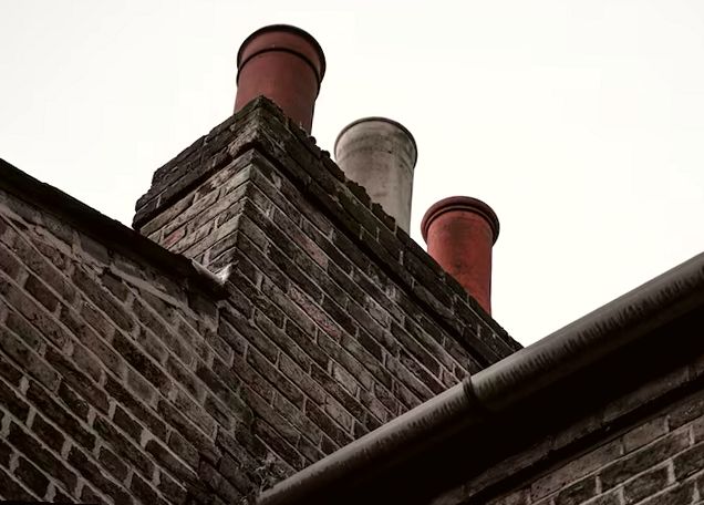 Clay chimney pots atop a dark brick stack