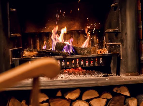 Logs burning brightly on a fireplace grate
