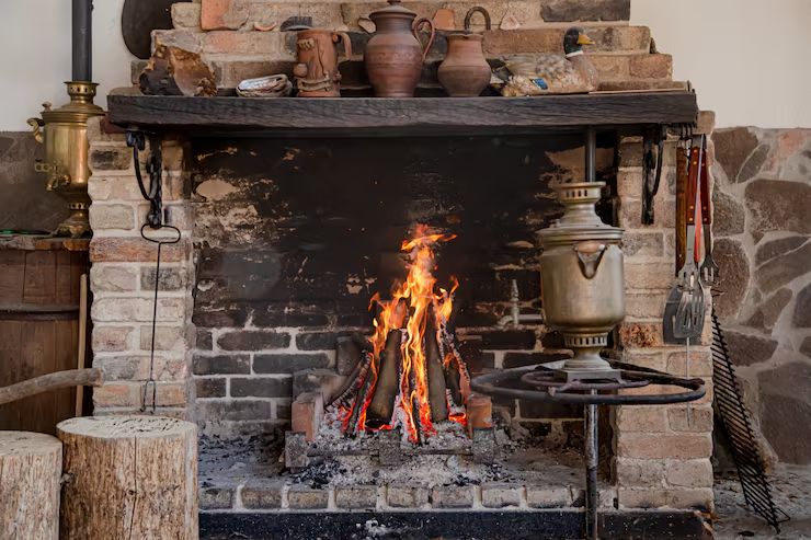Restored rustic brick hearth with a wood fire burning